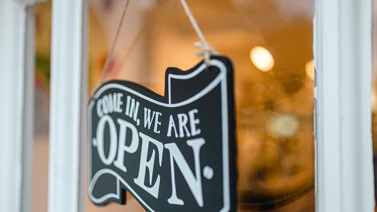 An open sign hanging in a shop window