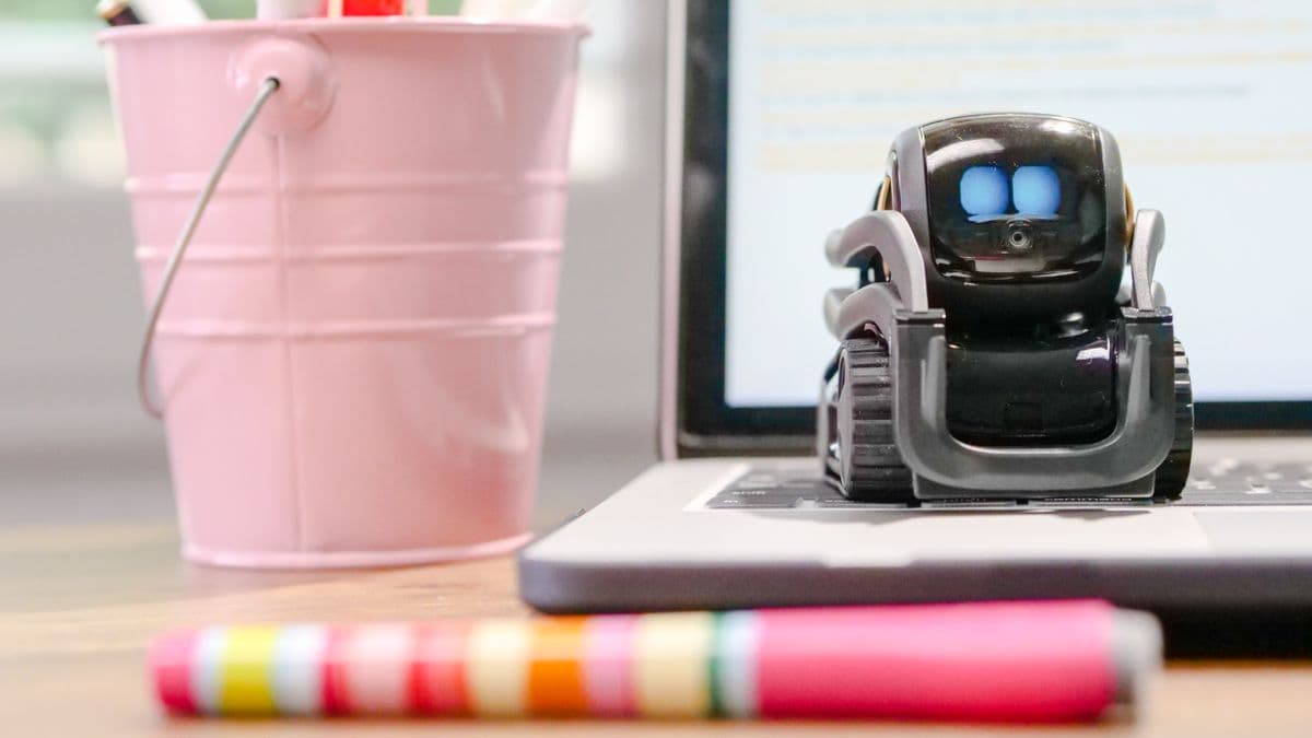 Un pequeño robot de juguete sobre el teclado de una laptop